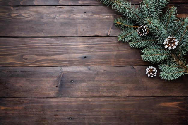 Weihnachtsbaum mit Kegeln auf einem dunklen hölzernen Hintergrund. Kopieren Sie Platz. Flach liegen.