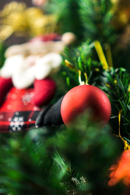 Weihnachtsbaum mit Ornamenten montiert. Rote, silberne und goldene Kugeln, Geschenkboxen, Lichter, Weihnachtsmann und andere. Selektiver Fokus.