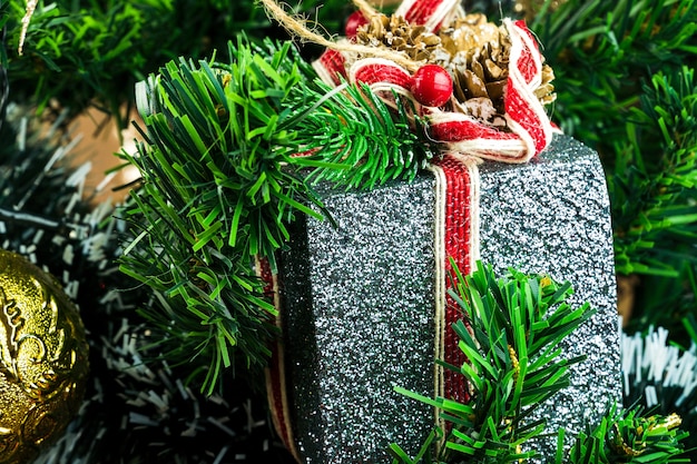 Weihnachtsbaum mit Ornamenten montiert. Rote, silberne und goldene Kugeln, Geschenkboxen, Lichter, Weihnachtsmann und andere. Selektiver Fokus.