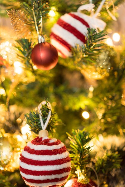 Weihnachtsbaum mit Ornamenten montiert. Rote, silberne und goldene Kugeln, Geschenkboxen, Lichter, Weihnachtsmann und andere. Selektiver Fokus.