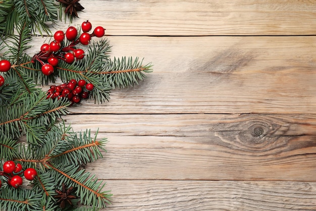 Weihnachtsbaum mit roten Beeren auf einem hölzernen Hintergrund