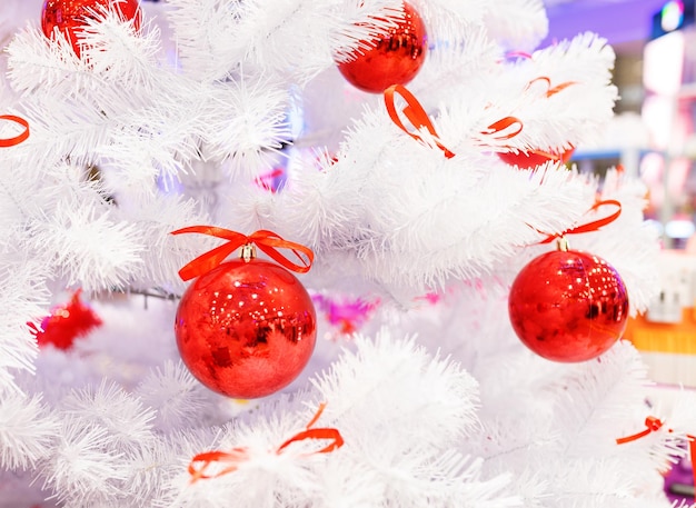 Weihnachtsbaum mit roten Kugeln. Weihnachtsbaum mit roten Kugeln. Konzept Feier Hintergrund des neuen Jahres. Weißer weihnachtsbaum mit roten kugeln und bunten geschenkboxen