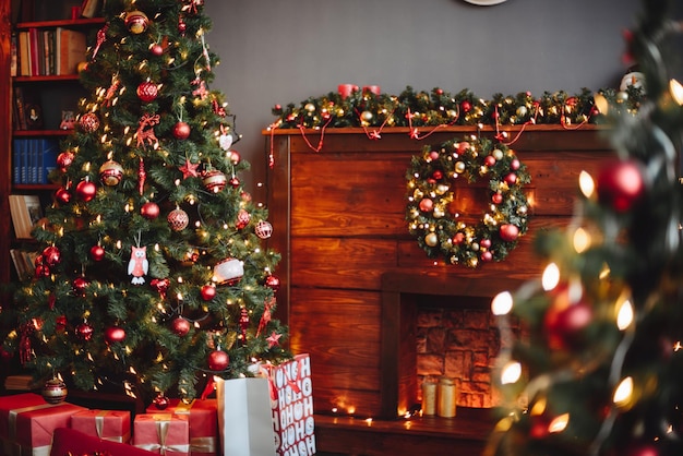 Foto weihnachtsbaum mit roten weihnachtsspielzeug-geschenken in roter verpackung kamin mit weihnachtsdekor