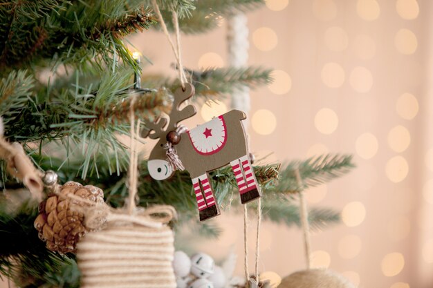 Weihnachtsbaum mit Spielwaren und dekorativem Schnee für ein guten Rutsch ins Neue Jahr auf Hintergrund von bokee