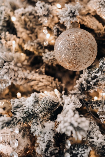 Weihnachtsbaum-Nahaufnahme. An Silvester ein geschmückter schneebedeckter Weihnachtsbaum.