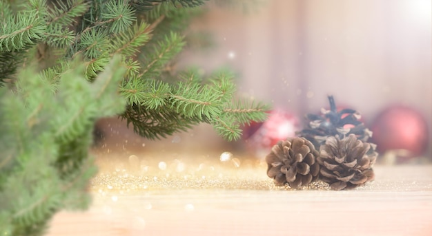 Weihnachtsbaum, Ornamente auf Holzfußboden. Defokussierte Lichter im Hintergrund.