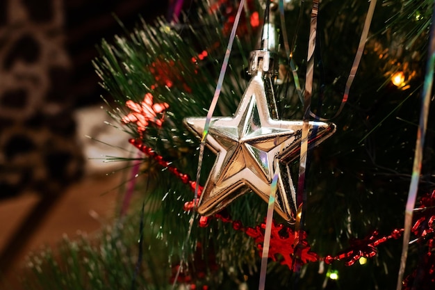 Weihnachtsbaum Spielzeugstern auf dem Hintergrund der Zweige der Tanne des neuen Jahres