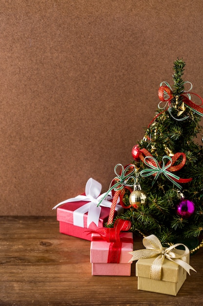 Weihnachtsbaum und Geschenkbox auf Holztischhintergrund