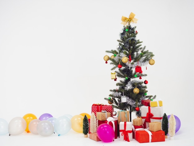 Weihnachtsbaum und Geschenkbox mit Ballon auf weißem Hintergrund