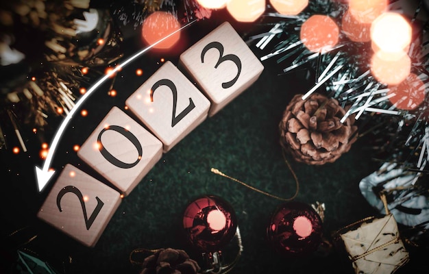 Foto weihnachtsbaum- und geschenkboxbälle bokeh-girlanden im unscharfen hintergrundwürfelblock, um den zweck der geschäftsüberwindung zu enthalten entwicklung von ideen für das neue jahr 2023x9