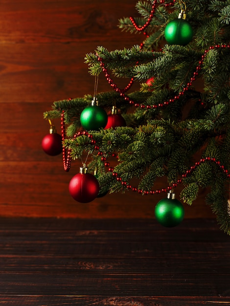 Weihnachtsbaum, verkleidet Kugeln, steht auf einem Holztisch.