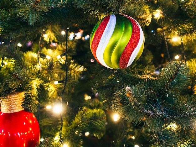 Weihnachtsbaum verziert mit einer Girlande und Weihnachtsspielzeug. Nahaufnahme