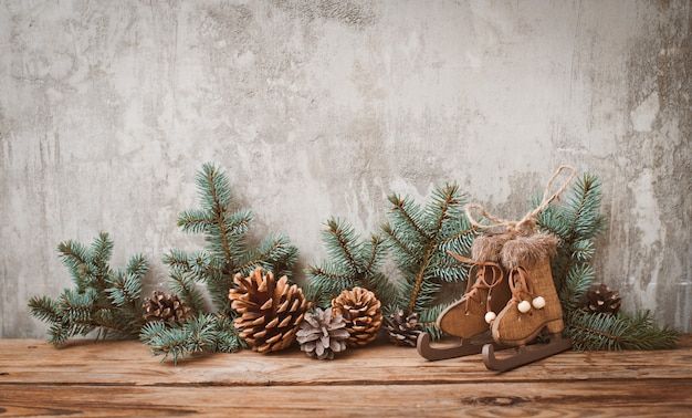 Weihnachtsbaumaste mit Kegeln auf einem dunklen hölzernen Brett