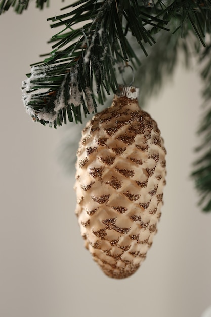 Weihnachtsbaumdekoration. Brauner Kegeldekor auf einem festlichen Hintergrund des Weihnachtsbaumastwinters.