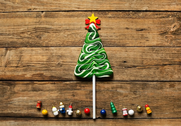 Weihnachtsbaumförmige Süßigkeiten liegen auf einem Holztisch