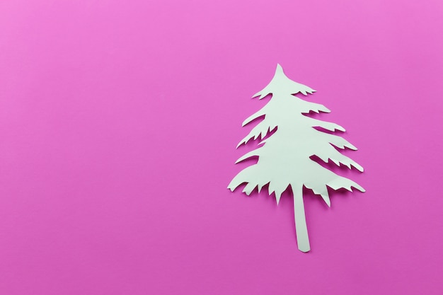Weihnachtsbaumform des Weißbuches auf rosa Papierhintergrund.