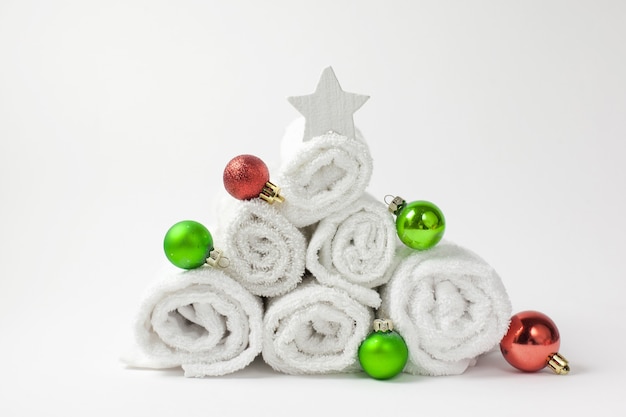 Weihnachtsbaumkomposition mit Handtüchern, Weihnachtskugeln und weißem Stern.