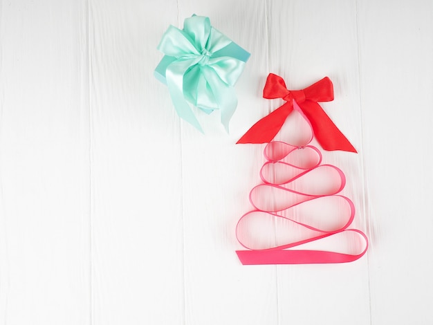 Weihnachtsbaumsatin-Rosaband, auf weißem Hintergrund, Kopienraum, Feiertag, Weihnachten, folgendes Weihnachtsgeschenk