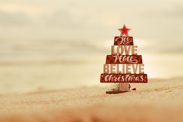 Weihnachtsbaumspielzeug aus Holz am Strand. Rustikaler Stil