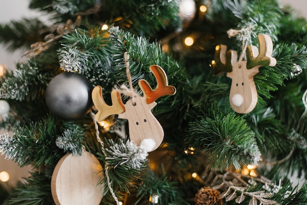 Weihnachtsbaumspielzeug aus Holz, Elch, der an einem Weihnachtsbaum mit Lichtern hängt