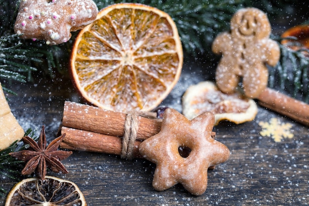 Weihnachtsbaumzweig, festliche Dekoration, Trockenfrüchte, hausgemachte Kekse und traditionelle saisonale Gewürze,