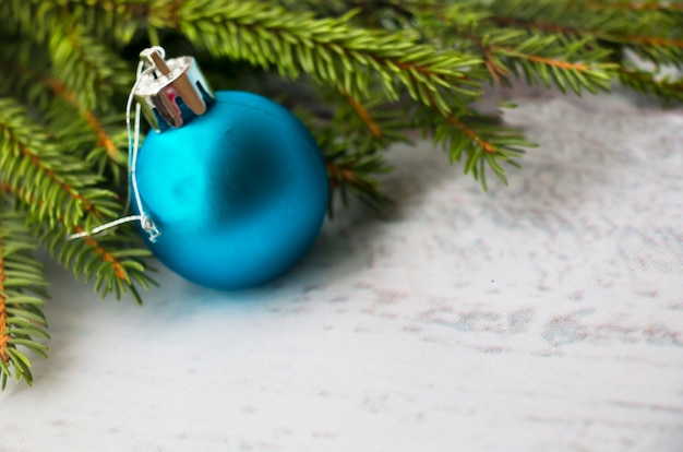 Weihnachtsbaumzweige auf blauem Hintergrund, blaue Kugel