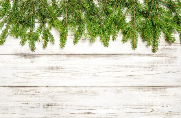 Weihnachtsbaumzweige auf hölzernem Hintergrund. Winterferienkonzept