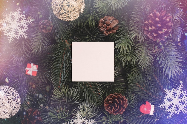 Weihnachtsbaumzweige mit Papierkartennotiz Flach lag Natur-Neujahrskonzept