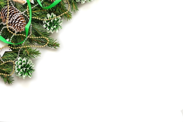 Weihnachtsbaumzweige mit Zapfen auf einem weißen Hintergrund.
