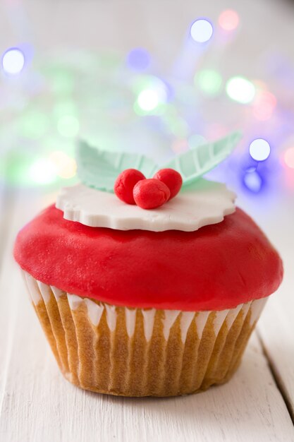 Weihnachtscupcake auf weißem Holztisch