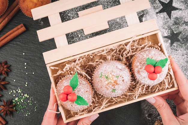 Weihnachtscupcakes verziert mit Mistel in einer Holzkiste