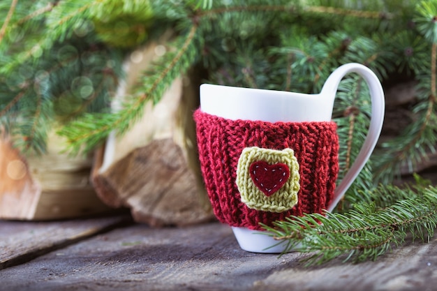 Weihnachtsdeko Gestrickte Wollbecher mit Bokeh am Holztisch