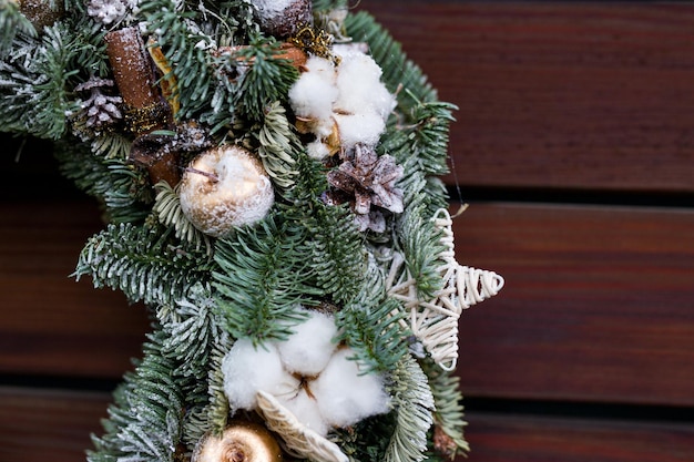 Weihnachtsdekor aus Nobilis-Tanne und Baumwolle und Zimt auf Holzhintergrund