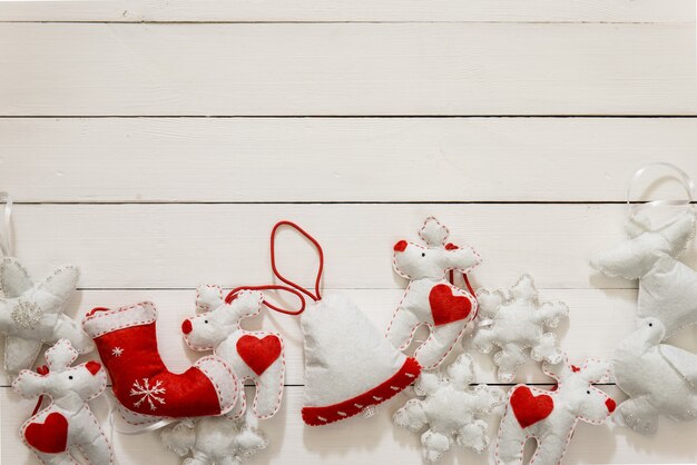 Weihnachtsdekoration auf dem hölzernen Hintergrund. Flache Lage mit handgemachter Glocke, Liebes, Schneeflocken in weißer Farbe