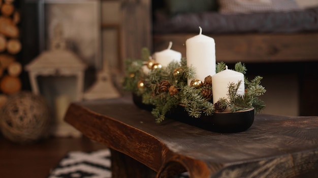 Weihnachtsdekoration auf Holztisch. Weiße Weihnachtskerzen auf einem Holztisch