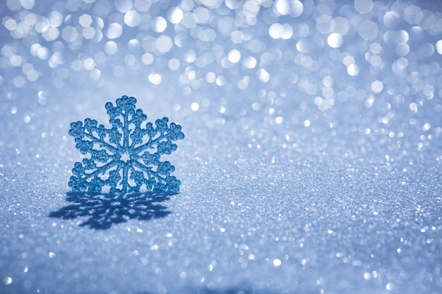 Weihnachtsdekoration auf Schnee vor verschwommenem Lichthintergrund