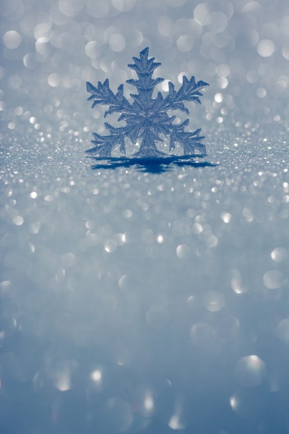 Weihnachtsdekoration auf Schnee vor verschwommenem Lichthintergrund