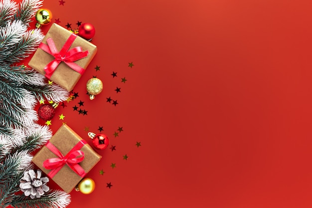 Weihnachtsdekoration Geschenke Geschenkbox, Tanne Äste, Kugeln auf rotem Hintergrund. Neujahr