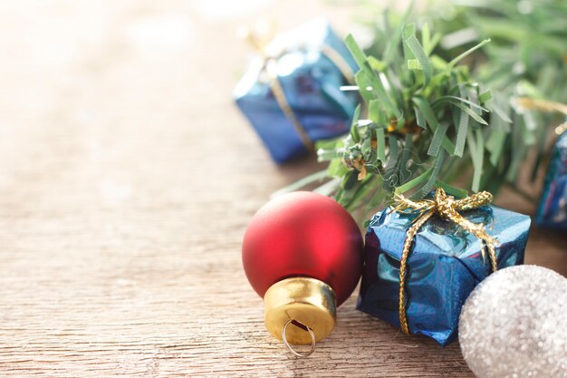 Weihnachtsdekoration. Geschenke und Weihnachtsbaumkugeln des neuen Jahres auf hölzernem Hintergrund