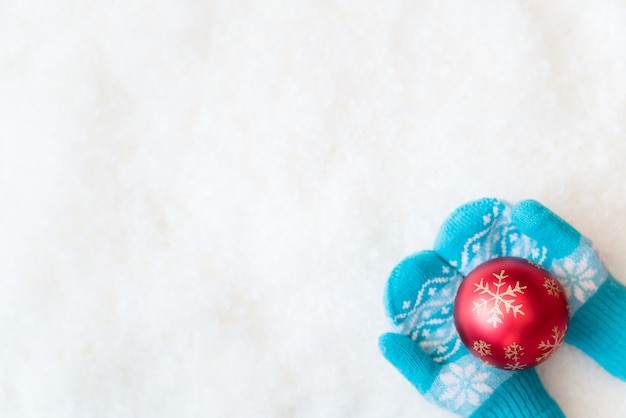 Weihnachtsdekoration in Kinderhänden auf Schnee