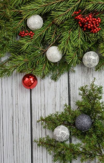 Weihnachtsdekoration mit Flitter und Kiefer auf hölzernem Hintergrund