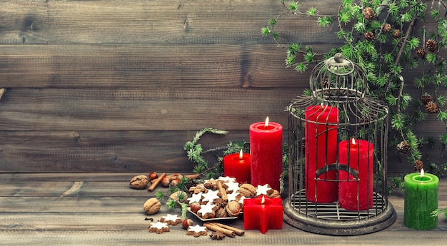 Weihnachtsdekoration mit roten Kerzen. Inneneinrichtung im Vintage-Stil. Zimtplätzchen, Nüsse und Gewürze