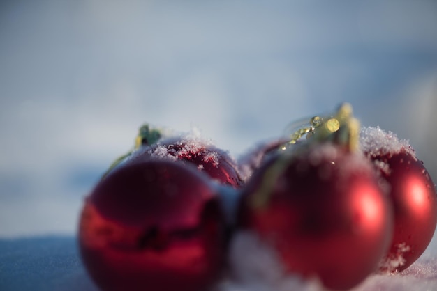 Weihnachtsdekoration mit roten Kugeln im frischen Schneehintergrund an einem schönen sonnigen Wintertag