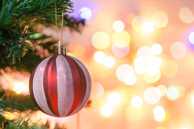 Weihnachtsdekoration. Rote Kugeln hängen an Tannenzweigen Weihnachtsbaumgirlande und Ornamente über abstraktem Bokeh-Hintergrund mit Kopierraum