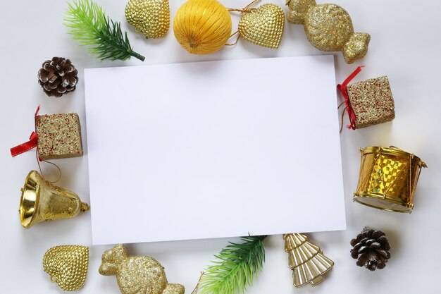 Weihnachtsdekoration und leere Papieranmerkung über weißen Hintergrund.