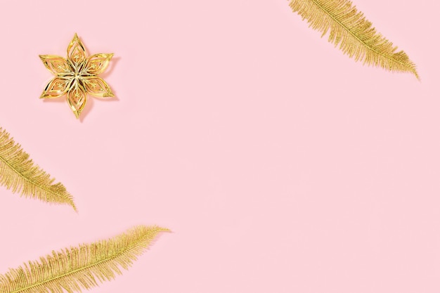 Weihnachtsdekorationen Feiertagshintergrund mit goldfarbenen Spielzeugen in Form von Stern- und Palmblättern