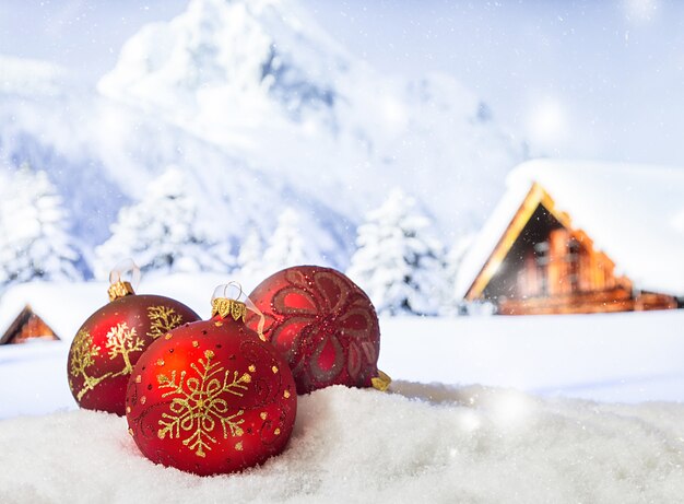 Weihnachtsdekorationen in einer Schneeverwehung vor der Winterweihnachtsoberfläche der schneebedeckten Berge