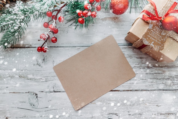 Weihnachtsdekorationsgeschenke mit einer Bastelkarte mit Kopienraum auf einem hölzernen Hintergrund