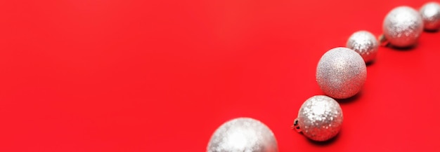 Weihnachtsdekorationskugeln auf rotem hellem Hintergrund