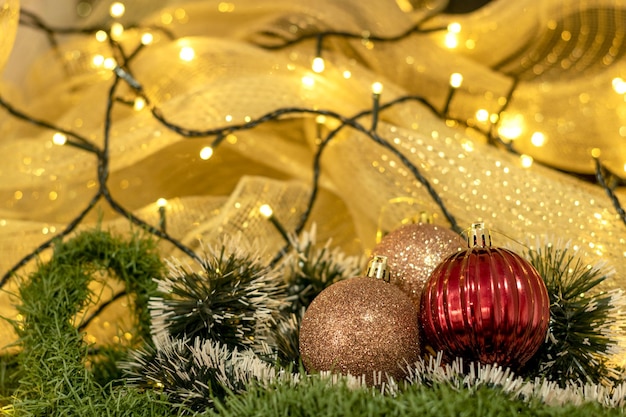 Weihnachtsdekorationskugeln mit Weihnachtsbeleuchtung und gelbem Hintergrund